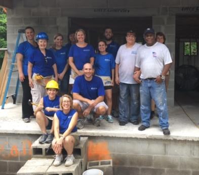 (Seminole employees and family members, in blue shirts, alongside homeowners Rhea and Melvin Robinson.)